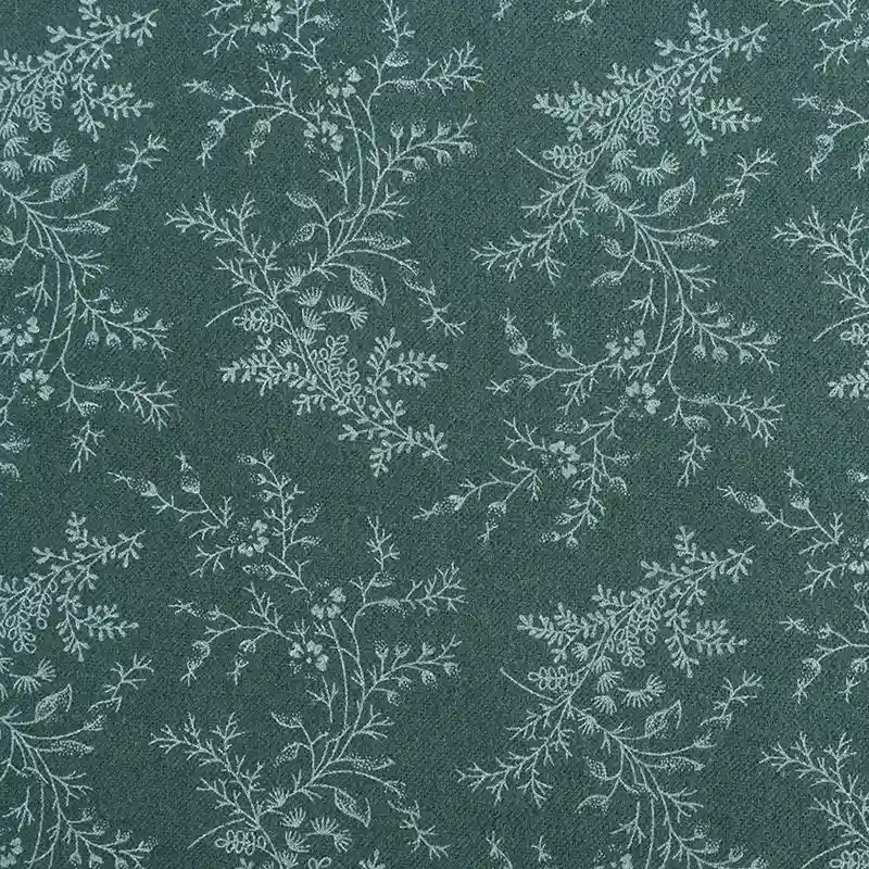 Gros plan sur la Flanelle de coton fleurie au mètre de Longan Craft France : fond vert foncé avec un motif feuillu vert clair répété, idéal pour les peignoirs, les vêtements d'hiver et les projets de couture créatifs.