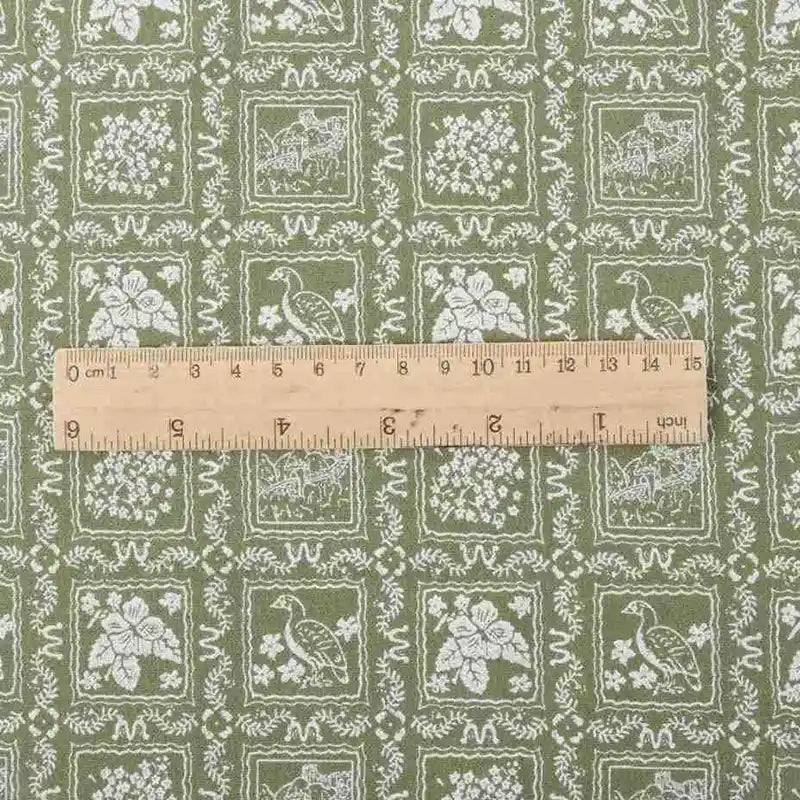 Une règle en bois est posée sur la "Flanelle de coton fleurie au mètre" de Longan Craft France, un tissu de flanelle de coton imprimé en automne avec des motifs floraux et pastoraux, idéal pour les robes, les vêtements et les projets de couture créatifs.