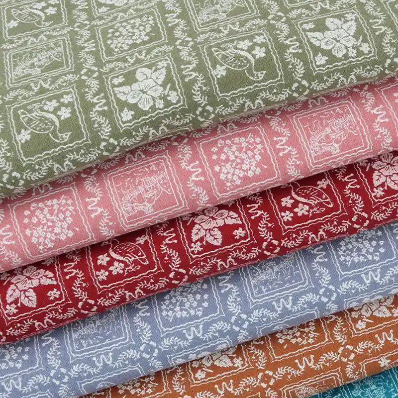 Une pile de cinq flanelles de coton colorées - vert, rose, rouge, bleu, marron - de Longan Craft France présente un motif floral et d'oiseaux blancs. Le tissu flanelle imprimé est idéal pour les robes de chambre, les vêtements ou les loisirs créatifs.