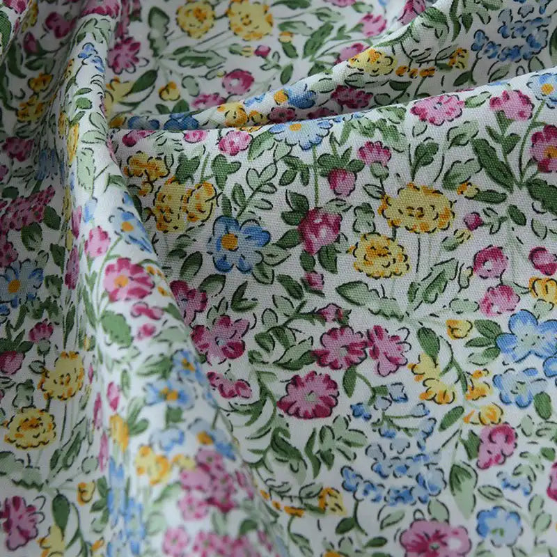 Popeline de coton à fleurs au mètre de Longan Craft France : tissu 100 % coton imprimé floral, doux et coloré, idéal pour quilting, nappes, robes et chemises. Léger et souple, avec motifs fleuris multicolores sur fond clair.