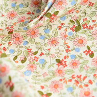 Gros plan sur la Popeline de coton à fleurs au mètre de Longan Craft France : tissu 100% coton doux, imprimé floral beige avec fleurs roses et corail, feuilles vertes et accents bleus. Idéal pour quilting, nappes, robes ou chemises.