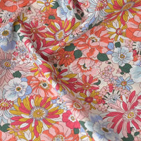 Un gros plan de Popeline de coton à fleurs au mètre de Longan Craft France montre un imprimé floral dense et coloré sur du coton doux à 100 % - idéal pour le quilting, les nappes, les robes ou les chemises - avec de légers plis et des détails texturés.