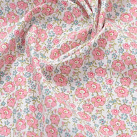 Popeline de coton à fleurs au mètre de Longan Craft France : tissu 100 % coton doux, imprimé floral avec petites fleurs roses et feuilles vertes sur fond blanc, légèrement froissé. Idéal pour quilting, nappes, robes et chemises.