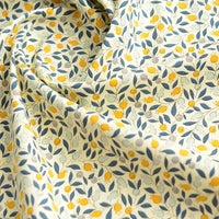 Gros plan sur Popeline de coton à fleurs au mètre de Longan Craft France, un tissu floral doux 100 % coton, bleu et jaune sur fond crème, idéal pour le quilting, les nappes, les robes et les chemises.