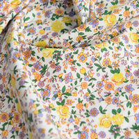 Gros plan sur la Popeline de coton à fleurs au mètre de Longan Craft France : popeline 100 % coton aux imprimés floraux colorés - roses jaunes, fleurs violettes, orange et bleues sur fond blanc. Douce et légèrement froissée, elle est idéale pour le quilting, les robes ou les nappes.