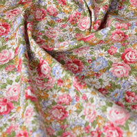 Gros plan sur la Popeline de coton à fleurs au mètre de Longan Craft France : motif floral dense rose, rouge, bleu et jaune sur une popeline douce 100% coton, légèrement froissée et drapée-un tissu parfait pour le quilting, les langes, les peignoirs et les chemises.