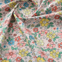 Gros plan sur la Popeline de coton à fleurs au mètre de Longan Craft France, un tissu floral doux 100 % coton avec des fleurs jaunes, roses, bleues et rouges sur fond beige. Légèrement froissé, il est parfait pour le quilting, les nappes, les robes ou les chemises.