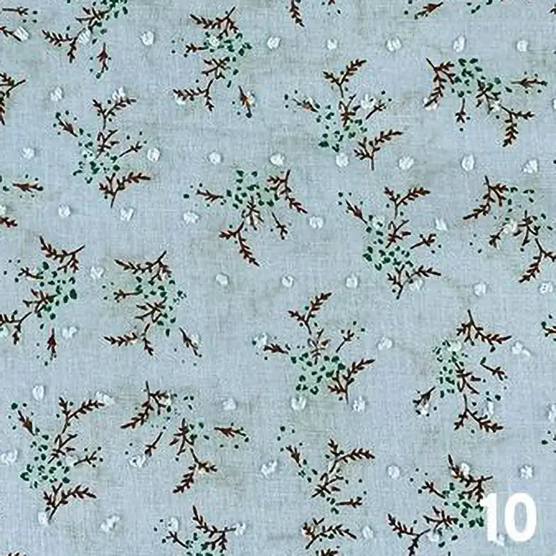 Le Tissu voile jacquard plumetis floral au mètre de Longan Craft France présente un voile de coton bleu clair avec de petites branches brunes, des feuilles vertes et des points blancs - parfait pour les robes d'été. Le chiffre "10" apparaît en blanc en bas à droite.
