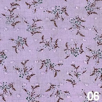 Tissu voile jacquard plumetis floral au mètre de Longan Craft France, en coton léger violet clair à motifs fleurs blanches et vertes, branches marron-parfait pour robes d'été. Le numéro "06" figure en bas à droite.
