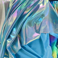 Un gros plan du Lamé irisé au mètre de Longan Craft France montre un tissu de polyester lamé métallique bleu-violet brillant et froissé, reflétant la lumière pour un éclat arc-en-ciel - idéal pour les costumes de couture et les représentations théâtrales.
