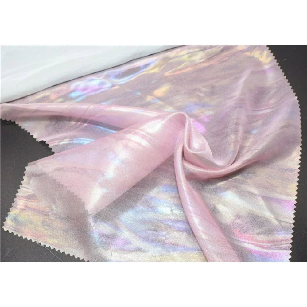 Une feuille de Mousseline irisée au mètre de Longan Craft France brille de reflets métalliques et arc-en-ciel. Cette mousseline en tissu de polyester est parfaite pour les projets de bricolage nécessitant une beauté pure et irisée.