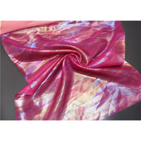 Un morceau de Mousseline irisée au mètre de Longan Craft France, une mousseline métallique de polyester brillante aux couleurs rose, violet, bleu et or avec des bords rosés, est étalé à plat avec un tourbillon au centre - parfait pour les fournitures de bricolage.