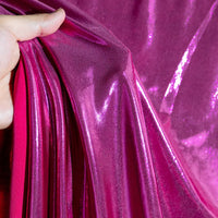 A hand gathers Longan Craft France Lamé métallique liquide au mètre, un tissu lamé vintage brillant et extensible qui réfléchit la lumière, idéal pour costumes de scène, robes de soirée et couture.