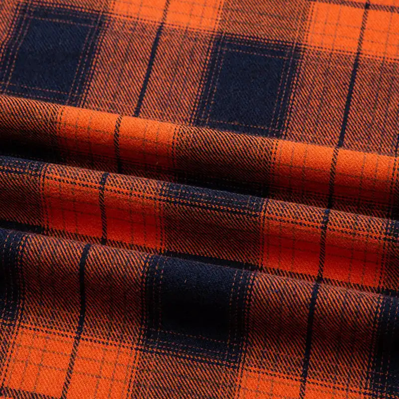 Gros plan sur la Flanelle de coton à carreaux au mètre Longon Craft France, montrant les lignes orange et bleu foncé de ce tissu flanelle confortable, parfait pour chemises, robes ou pantalons d'automne.