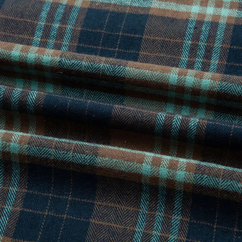 Découvrez la Flanelle de coton à carreaux au mètre de Longon Craft France : un tissu flanelle doux aux motifs bleu foncé, brun et sarcelle, idéal pour chemises, robes ou pantalons automne/hiver.