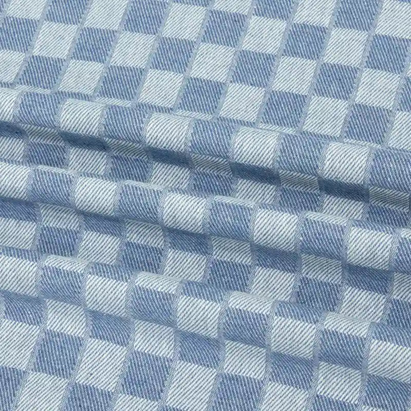 Gros plan sur la Flanelle de coton à carreaux au mètre de Longon Craft France, une douce étoffe tissée bleue et blanche idéale pour les chemises, les robes et les pantalons d'automne, avec une texture douillette parfaite pour des vêtements d'hiver confortables.