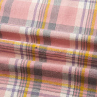 Gros plan sur la flanelle de coton à carreaux au mètre de Longon Craft France : motif écossais rose avec des lignes jaunes, grises et violettes. Ce tissu doux et confortable est parfait pour les chemises, les robes et les pantalons d'automne.