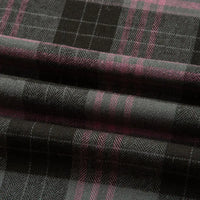 Un gros plan de la Flanelle de coton à carreaux au mètre de Longon Craft France montre son plaid noir et gris avec de fines rayures roses, mettant en valeur la texture confortable de la flanelle, idéale pour les chemises, les robes et les pantalons d'automne.