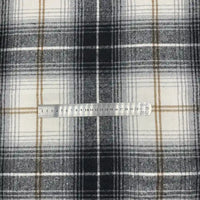 Une règle en métal repose sur le Tissu en flanelle à carreaux pour l'automne au mètre de Longon Craft France, un tissu polyester-coton doux et confortable, idéal pour robes, chemises ou couture d'hiver.