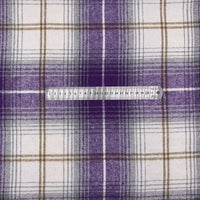 Une règle métallique indiquant les centimètres et les millimètres est posée sur le tissu en flanelle à carreaux pour l'automne au mètre de Longon Craft France, un tissu en polyester-coton idéal pour les peignoirs, les chemises et la couture d'hiver.