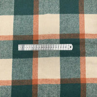 Une règle en métal indiquant les centimètres et les millimètres repose sur le tissu en flanelle à carreaux pour l'automne-un tissu polyester-coton confortable, idéal pour robes, chemises ou vêtements d'hiver de Longon Craft France.