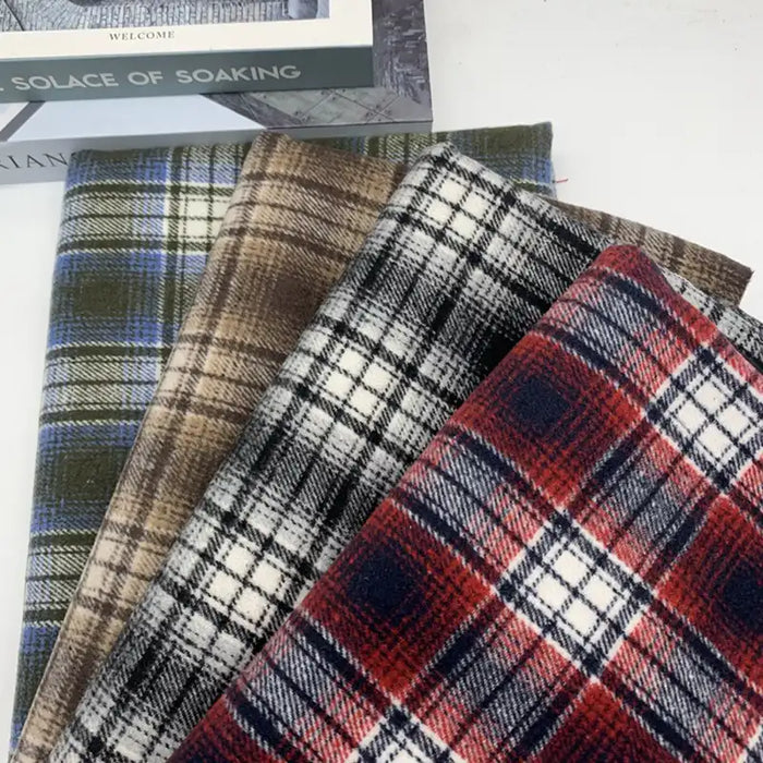 Quatre coupons de Tissu en flanelle à carreaux pour l'automne au mètre Longon Craft France, en vert, marron, noir-blanc et rouge, sont disposés côte à côte sur une surface blanche. Idéal pour robes et chemises d'hiver.