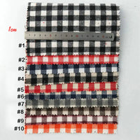 Dix échantillons numérotés de Tissu flanelle à carreaux au mètre de Longon Craft France, une flanelle colorée et douillette en polyester-coton pour la couture festive, sont empilés à côté d'une règle de 1 cm, parfaite pour les projets de textile d'ameublement.