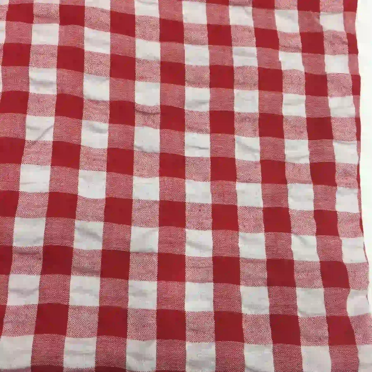 Le tissu seersucker à carreaux au mètre de Longan Craft France présente un motif classique vichy rouge et blanc, léger, idéal pour les vêtements d'été.