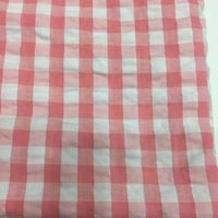 Découvrez le Tissu seersucker à carreaux au mètre de Longan Craft France : un seersucker vichy rose et blanc, léger et légèrement froissé, idéal pour vêtements d'été. Présenté à plat avec des carreaux réguliers.