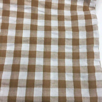 Découvrez le Tissu seersucker à motif vichy de Longan Craft France : un tissu léger à carreaux marron clair et blanc, légèrement gaufré, idéal pour des vêtements d'été. Disponible au mètre.