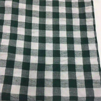 Un gros plan du "Tissu seersucker à carreaux au mètre" de Longan Craft France montre son motif écossais vichy noir et blanc avec des carrés régulièrement espacés en tissu seersucker texturé.