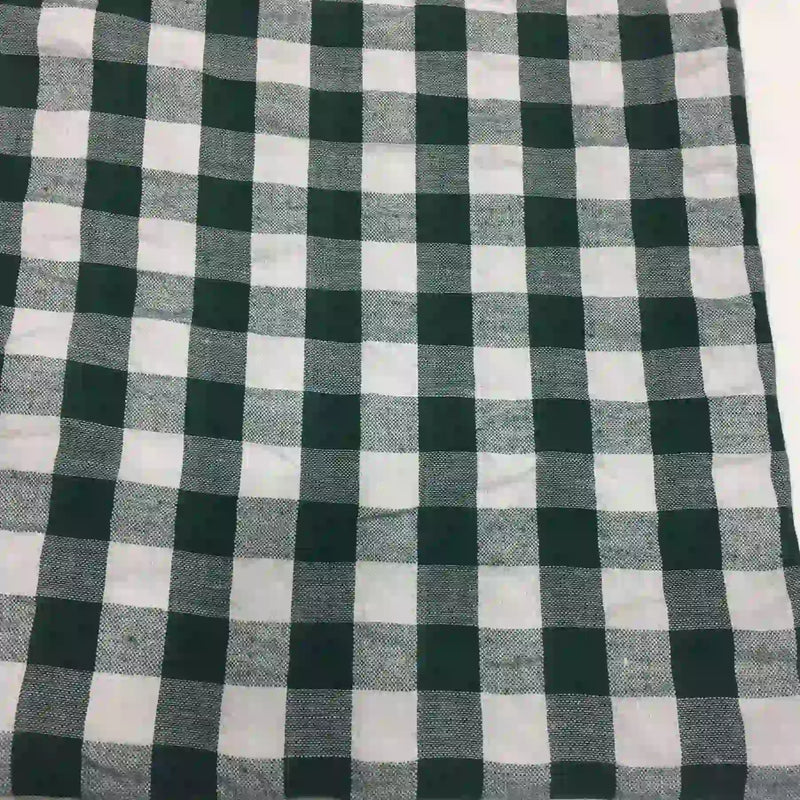 Un gros plan du "Tissu seersucker à carreaux au mètre" de Longan Craft France montre son motif écossais vichy noir et blanc avec des carrés régulièrement espacés en tissu seersucker texturé.