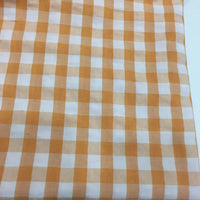 Gros plan sur le Tissu seersucker à carreaux au mètre de Longan Craft France, qui présente un motif à carreaux vichy orange et blanc, idéal pour les vêtements d'été légers.