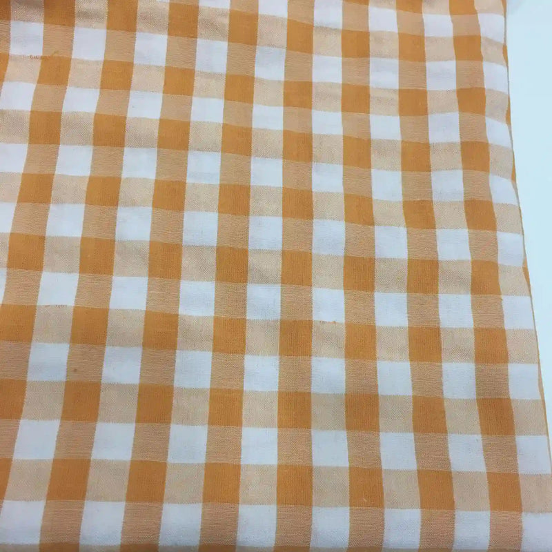Gros plan sur le Tissu seersucker à carreaux au mètre de Longan Craft France, qui présente un motif à carreaux vichy orange et blanc, idéal pour les vêtements d'été légers.