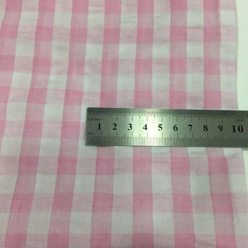Le tissu seersucker à carreaux au mètre de Longan Craft France est présenté avec une règle en métal indiquant la largeur en centimètres. Ce tissu léger à motif vichy est parfait pour les tenues estivales et les vêtements d'été.