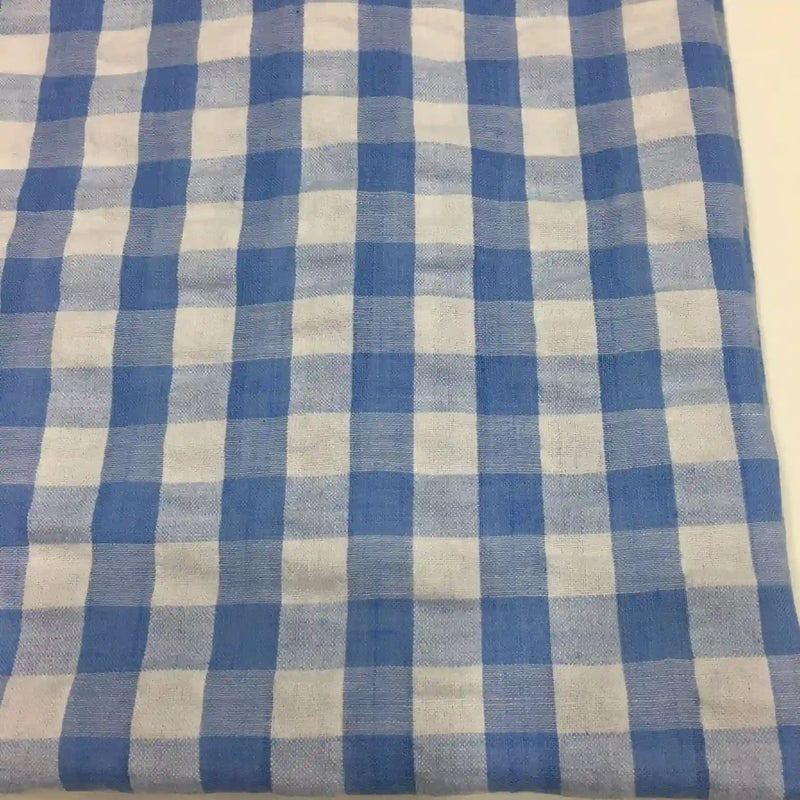 Le Tissu seersucker à carreaux au mètre de Longan Craft France est un tissu vichy bleu et blanc en mélange polyester-coton, idéal pour les vêtements d'été grâce à sa légèreté et son design classique.