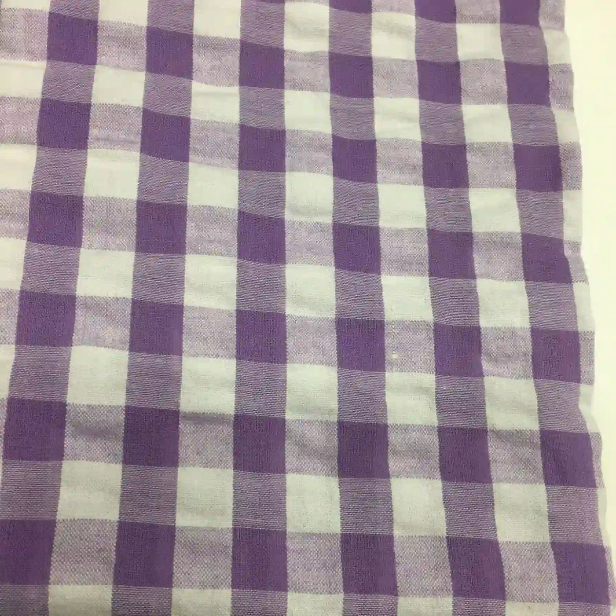 Le tissu seersucker à carreaux au mètre de Longan Craft France, présenté en violet et blanc à motif vichy, offre une texture légère et légèrement gaufrée, idéale pour des vêtements d'été confortables.