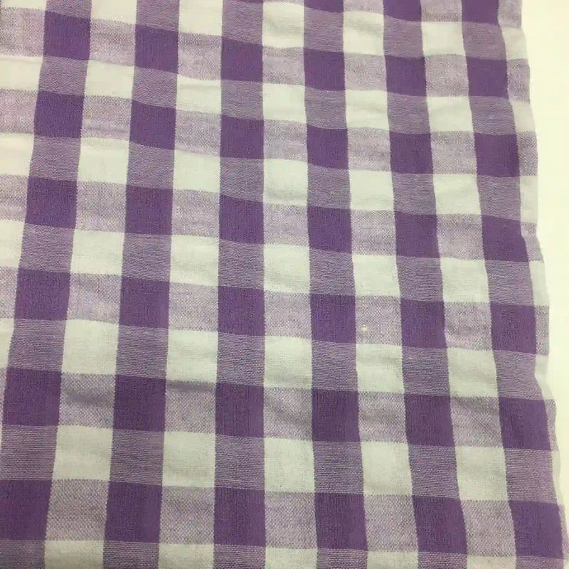 Le tissu seersucker à carreaux au mètre de Longan Craft France, présenté en violet et blanc à motif vichy, offre une texture légère et légèrement gaufrée, idéale pour des vêtements d'été confortables.