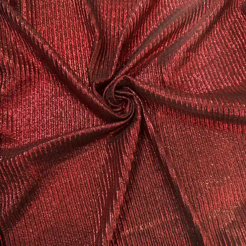 Un gros plan sur le tissu lamé plissé au mètre de Longan Craft France met en valeur son polyester rouge métallisé, nervuré et chatoyant, agencé selon un motif tourbillonnant qui reflète magnifiquement la lumière. Il est idéal pour la couture, les robes DIY et l'artisanat.