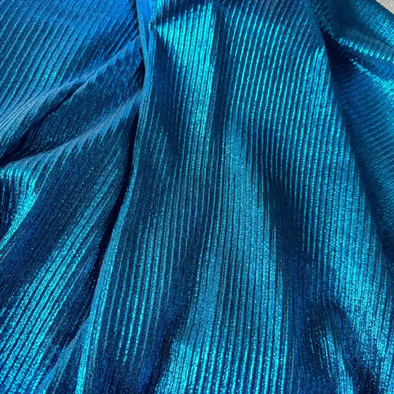 Gros plan sur le Tissu lamé plissé au mètre de Longan Craft France - polyester brillant, côtelé et extensible avec effet métallique. La lumière met en valeur les lignes texturées, ajoutant de l'élégance à ce tissu pour la couture, les peignoirs DIY et l'artisanat.