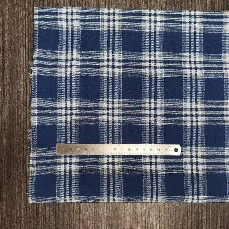 Découvrez le Tissu flanelle à carreaux polyester-coton au mètre de Longon Craft France, un tissu doux à carreaux bleus et blancs, idéal pour les projets de vêtements d'automne ou de bébé.
