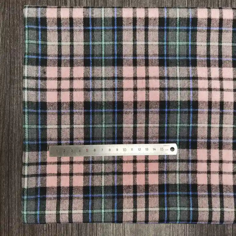 A piece of Longon Craft France tissu flanelle à carreaux polyester-coton, idéal pour l'automne et la couture de vêtements bébé, is posé sur une surface grise avec une règle de 20 cm placée au centre.