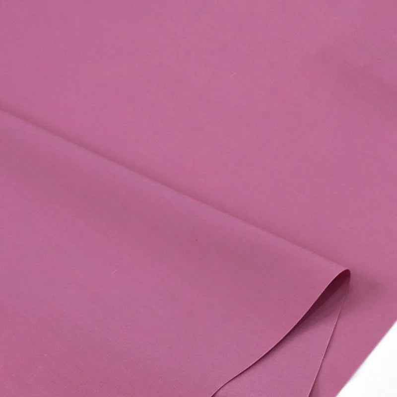 Gros plan sur Popeline polyester-coton au mètre de Longan Craft France, un tissu popeline doux et respirant, lisse et violet clair, soigneusement plié et posé à plat, idéal pour les peignoirs, chemises et couches.