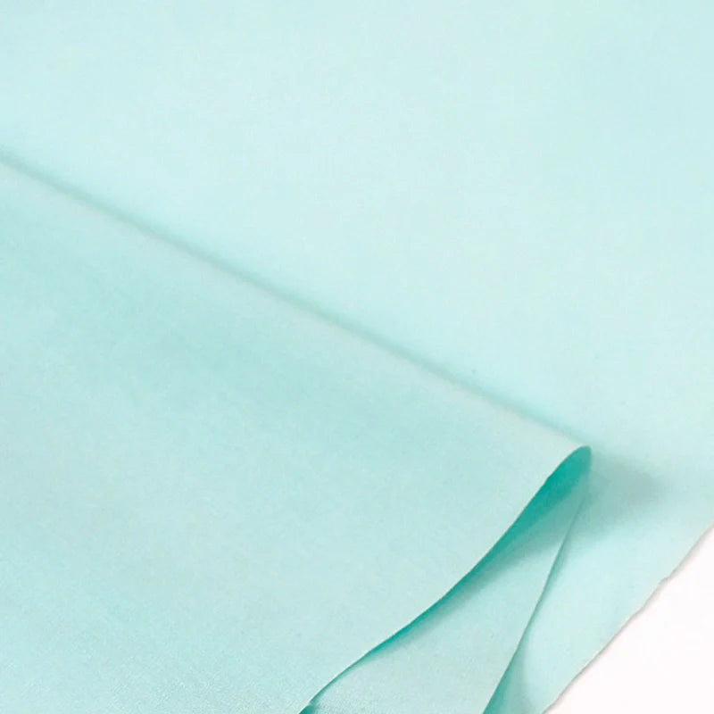 Un gros plan du Popeline polyester-coton au mètre de Longan Craft France montre sa texture douce et légère et sa toile d'armure respirante, parfaite pour les peignoirs, les chemises ou les couches.