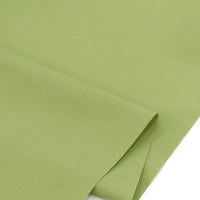 Un gros plan du Popeline polyester-coton au mètre de Longan Craft France montre sa texture lisse et vert clair. Ce tissu popeline doux et respirant à armure toile est idéal pour les peignoirs, les chemises et les couches grâce à sa durabilité.