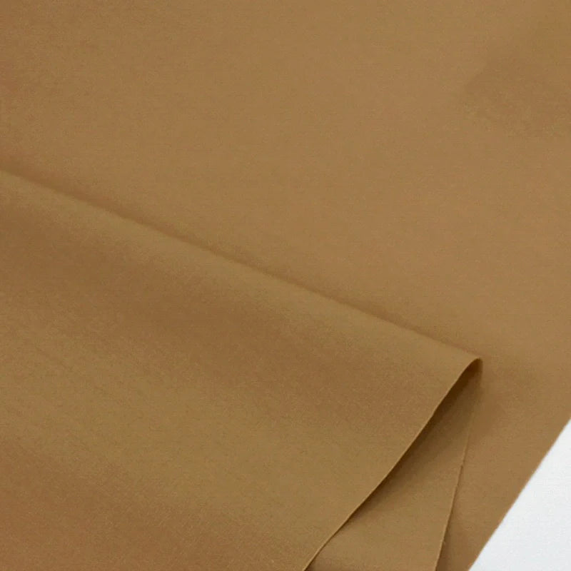 Un gros plan de deux pièces de Popeline polyester-coton au mètre de Longan Craft France, l'une pliée sur l'autre, met en évidence la texture lisse et la finition mate de ce doux et respirant tissu popeline uni pour les peignoirs, les chemises et les couches.