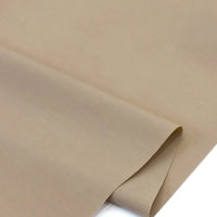 Gros plan sur le Popeline beige polyester-coton au mètre de Longan Craft France, doux et respirant à armure toile, avec coin replié. Tissu popeline uni idéal pour robes, chemises, nappes ou décoration intérieure.