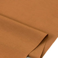 Gros plan sur Popeline polyester-coton au mètre de Longan Craft France, un tissu popeline uni à armure toile, marron clair, doux et respirant, soigneusement plié pour montrer sa texture lisse et régulière pour les peignoirs, chemises et langes.