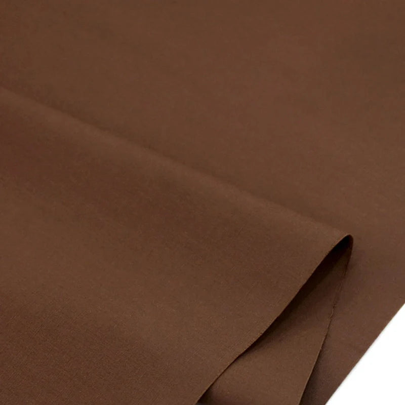 Gros plan sur la popeline polyester-coton au mètre de Longan Craft France, soigneusement pliée pour montrer sa texture lisse et régulière - parfaite pour les peignoirs, les chemises, les couches ou la décoration intérieure.