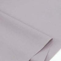 Gros plan sur Popeline polyester-coton au mètre de Longan Craft France, un doux et respirant tissu popeline uni à armure toile, montrant des couches lisses qui se chevauchent - idéal pour les peignoirs, les chemises, les couches ou la décoration intérieure.
